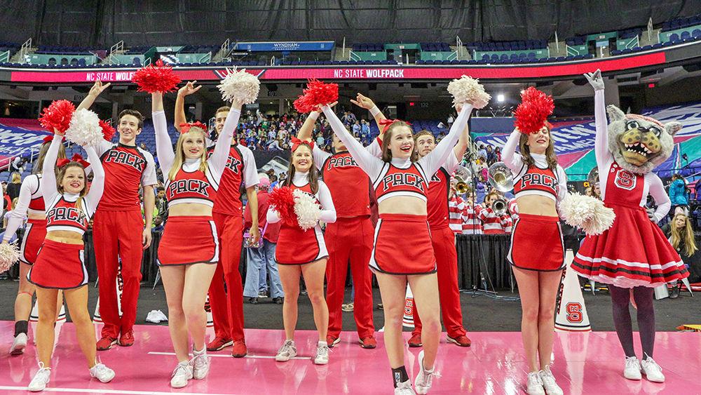 The cheerleading team throws up their wolfies as the stadium lights up Wolfpack Red after the 77-64 win over UNC-CH in the Greensboro Coliseum on Thursday, March 1 to head to the quarter finals of the ACC tournament.