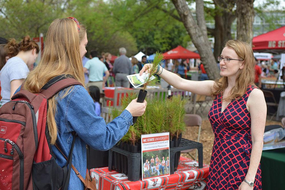 Beverly Setzer, a junior studying mathematics, is handed a loblolly pine by Kimber Lunsford, the assistant director of undergraduate programs for the Department of Forestry and Environmental Resources, during the Earth Fair in the Brickyard on April 5, 2017. Setzer was the president of the Good Club, a student group that was also set up during the fair. "We had 900 plants and we sold out within an hour and a half," Setzer said.