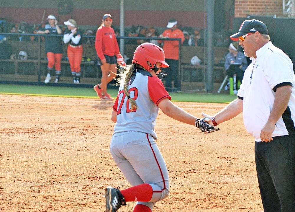 Haylee Kobziak, a sophomore infielder, gets a handshake from head coach Shawn Rychcik on her way to home base after hitting a home run during the game against Campbell University on Wednesday in Dail Softball Stadium. The Wolfpack beat the Fighting Camels 6-5 for their 21st win this season.