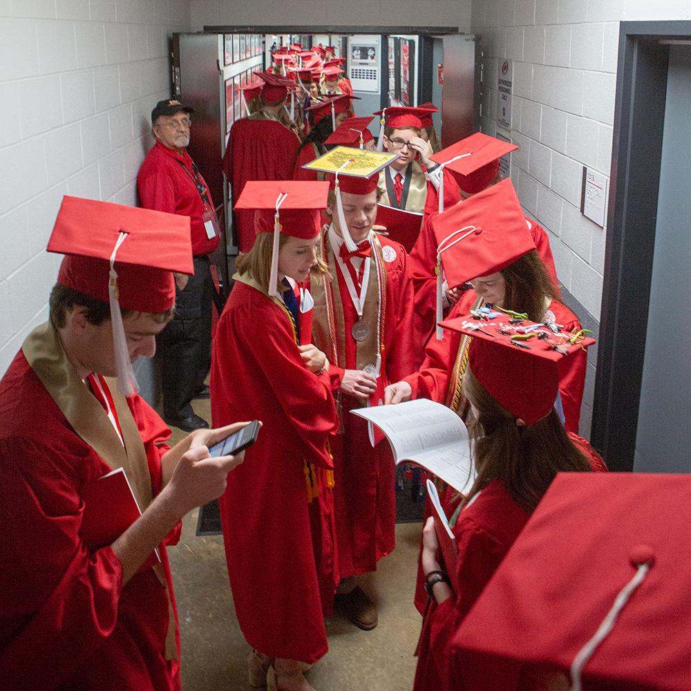 Students stand in the hallway underneath waiting friends and family prior to the start of Spring Commencement on Saturday, May 12 in PNC Arena.
