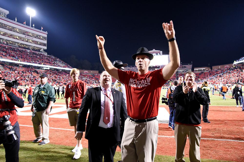 Head coach Dave Doeren wears Dr. Daniel Monek's fedora and throws up the signature "wolfie" sign with his hands in celebration of NC State's victory over UNC-Chapel Hill in Carter-Finley Stadium on Saturday. The Wolfpack claimed its eighth win of the season.