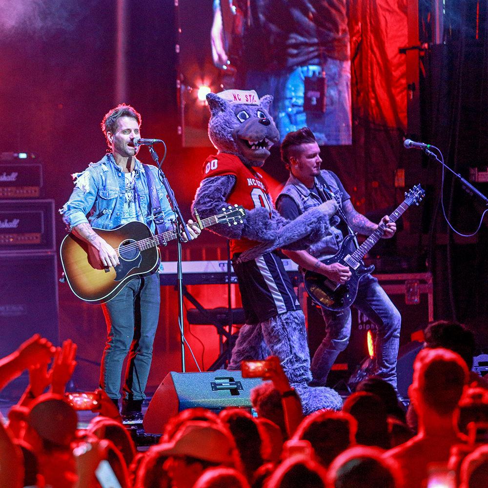 Mr. Wuf plays his tail as Parmalee's Josh McSwain jams on guitar and Matt Thomas sings during Packapalooza on Saturday, August 25.
