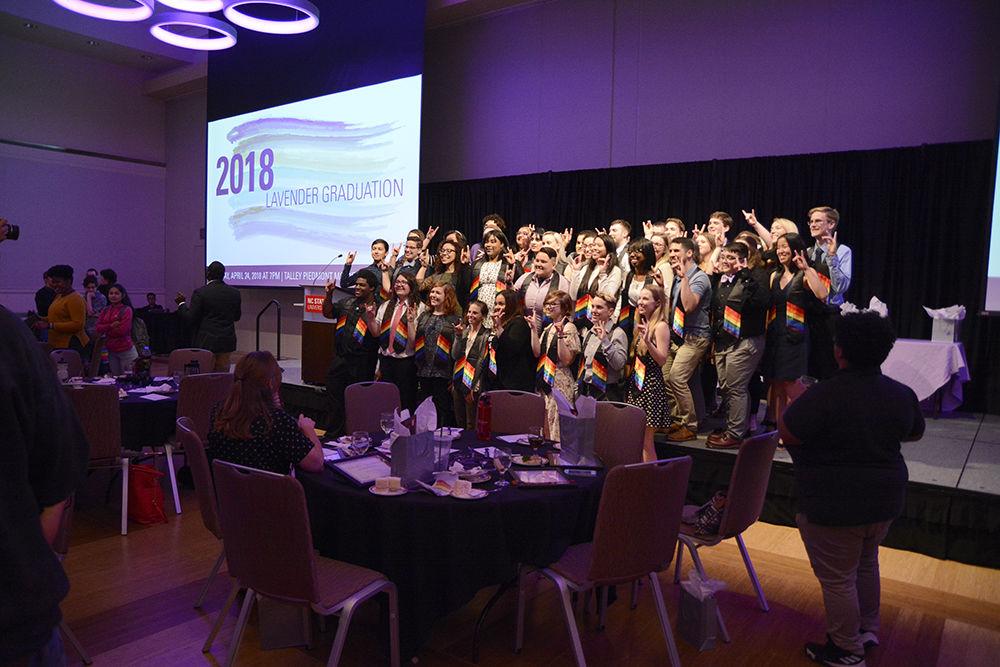 The graduating class of the GLBT Center at NC State University put up wolfies and pose for a group photo at Lavender Graduation in Talley ballroom on Tuesday. The event honors the contributions of the LGBT community at NC State in advocacy, producing change, and growing as individuals of the student population at N.C. State.