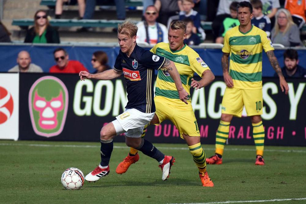 North Carolina FC midfielder Kyle Bekker dribbles away from opponents on Saturday, March 17 at Sahlen's Stadium at WakeMed Soccer Park. NCFC lost to the Tampa Bay Rowdies 3-1.