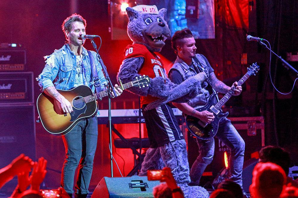 Mr. Wuf plays his tail as Parmalee's Josh McSwain jams on guitar and Matt Thomas sings during Packapalooza on Saturday.