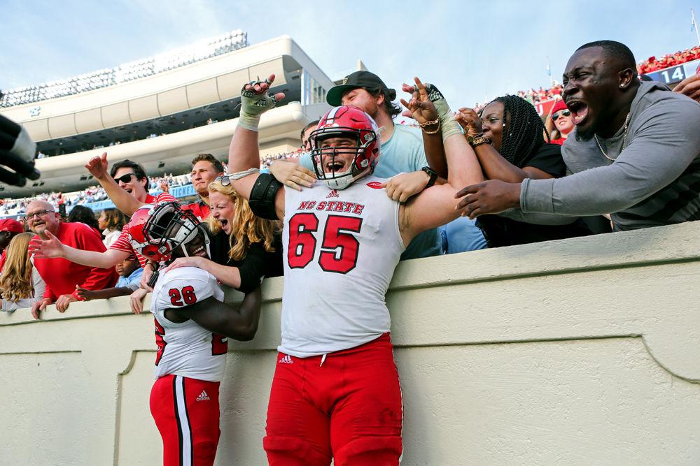 Graduate center Garrett Bradbury celebrates with fans after the win over UNC in Kenan Memorial Stadium on Nov. 25, 2016. The Wolfpack won 28-21.