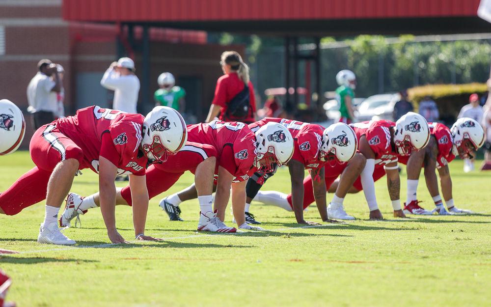 The running backs take time to stretch after warming up for practice Thursday morning.