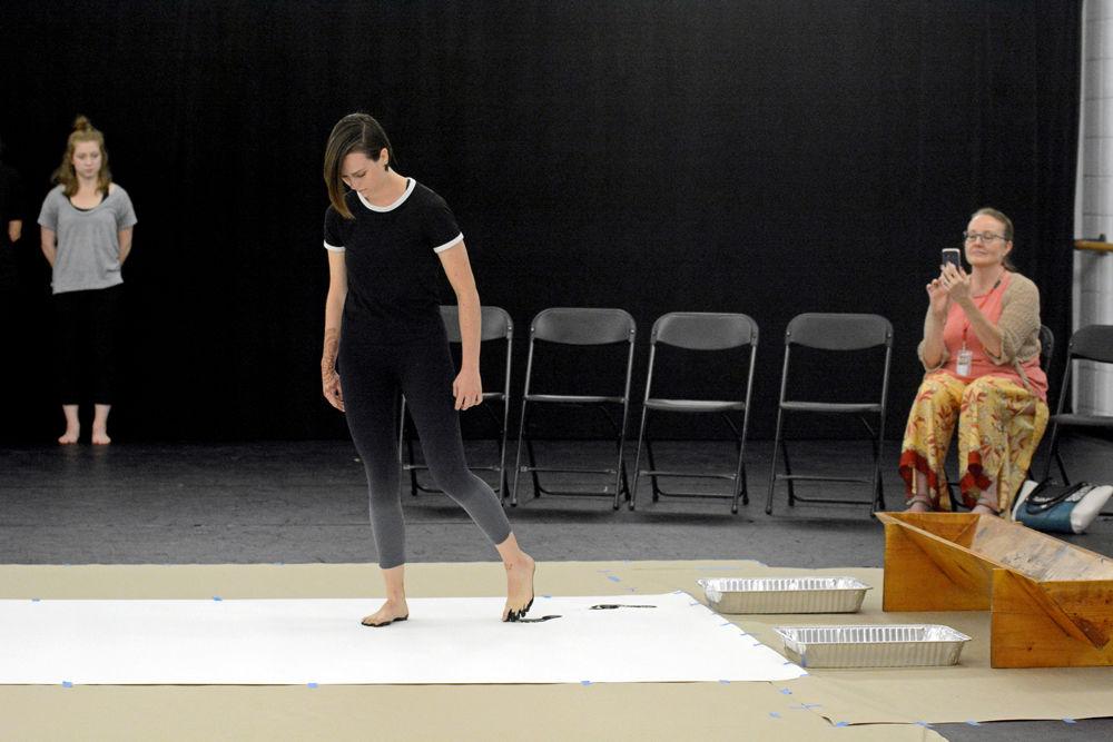 Casey Graff, a second-year studying animal science and a member of NCSU Dance Company, is the first dancer to begin "John Cage's STEPS" by leaving her footprints on a long piece of paper after stepping in black paint. This composition was the feature of a Master Class hosted by the NC State Dance Program in Carmichael Gymnasium on Wednesday, Sept. 19.