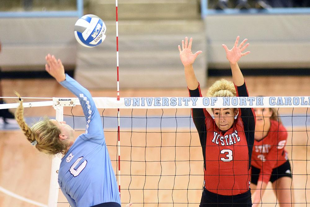 Sophomore opposite hitter Melissa Evans attempts to block a spike from UNC junior opposite hitter Skylar Wine at Carmichael Arena in Chapel Hill on Wednesday, Sept. 27. The Wolfpack lost to UNC 3-1.