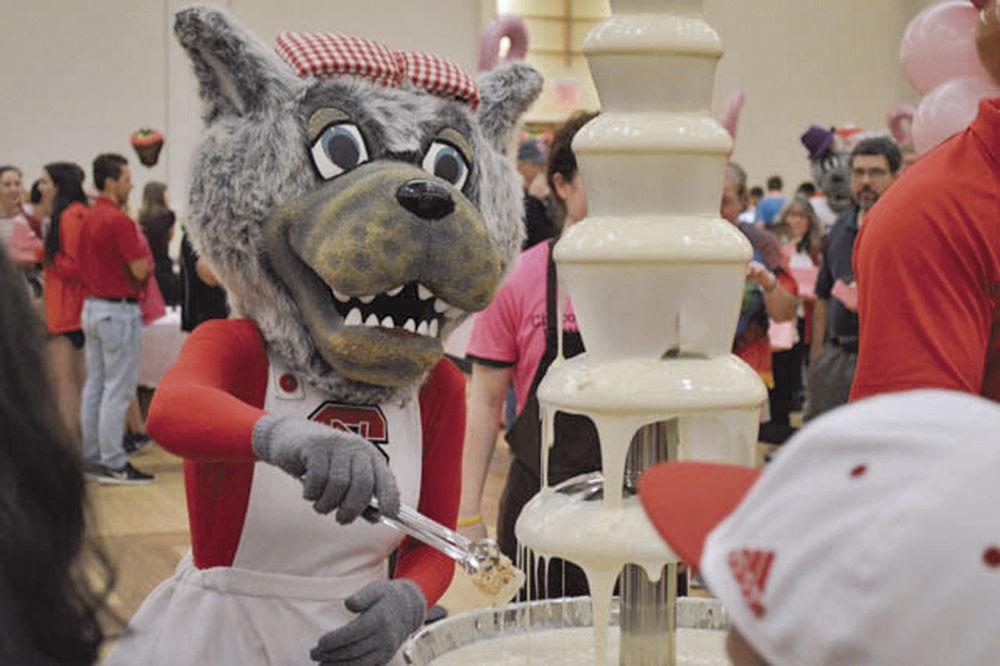 Ms. Wuf dips a Rice Krispies Treat into the white chocolate fountain during the 13th annual Chocolate Festival in the State Ballroom in Talley Student Union on Sept. 30, 2016.