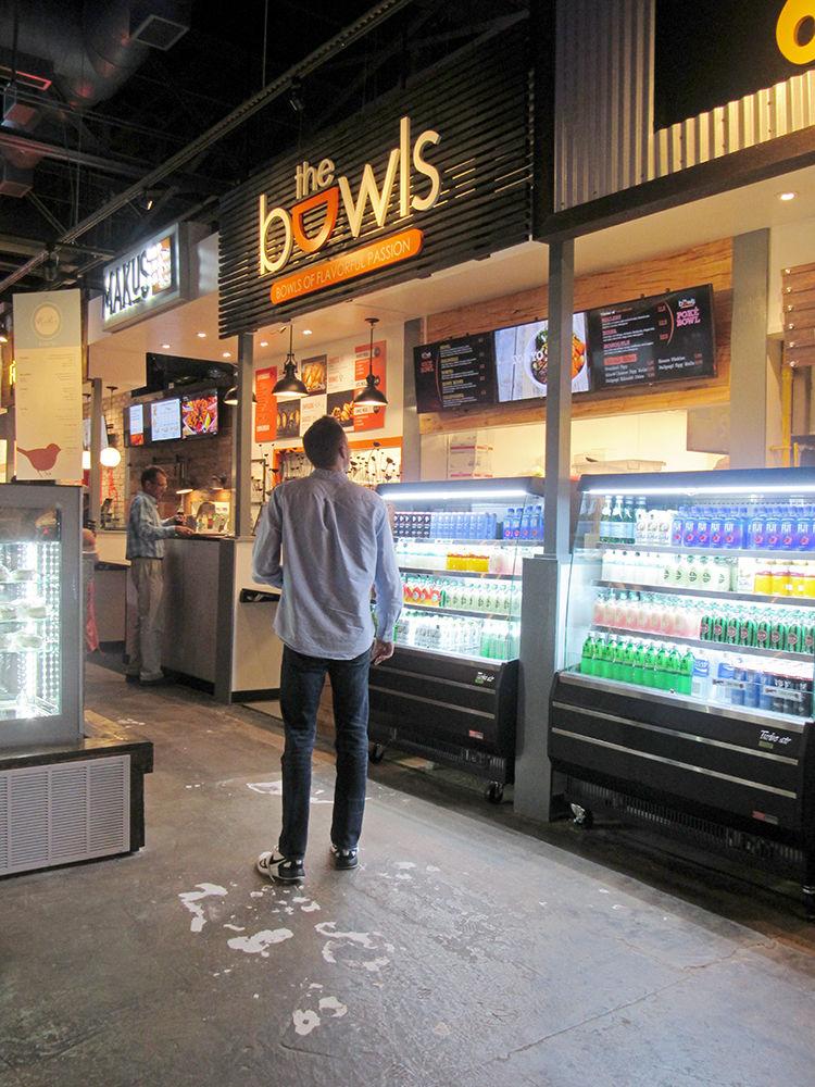 Raleigh resident Nick Vondrachek, 24, scans a menu at Morgan Street Food Hall on Sep. 5. Morgan Street Food Hall opened this summer and features local restaurants in an open dining hall.