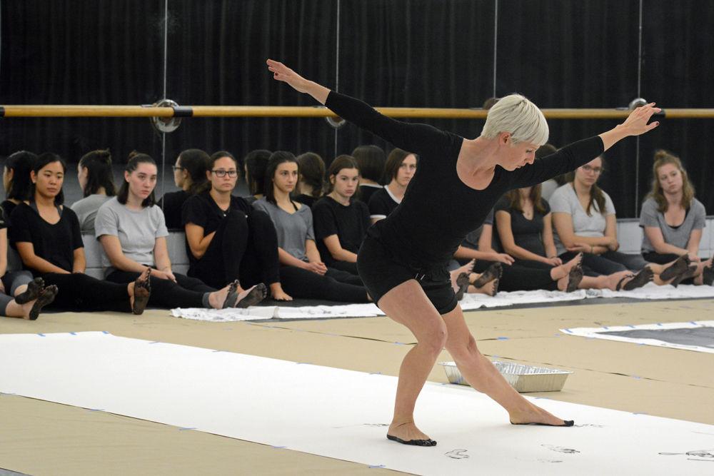 Justin Tornow, a dancer and choreographer based in Durham, dances on her own piece of paper, leaving footprints behind her during the Master Class entitled "John Cage's STEPS: A Composition For A Painting" at Carmichael Gymnasium on Wednesday, Sept. 19. When asked about the inspiration for her dancing during the Master Class, Tornow said, "It was just improv." and that she made it a point to "move backwards."
