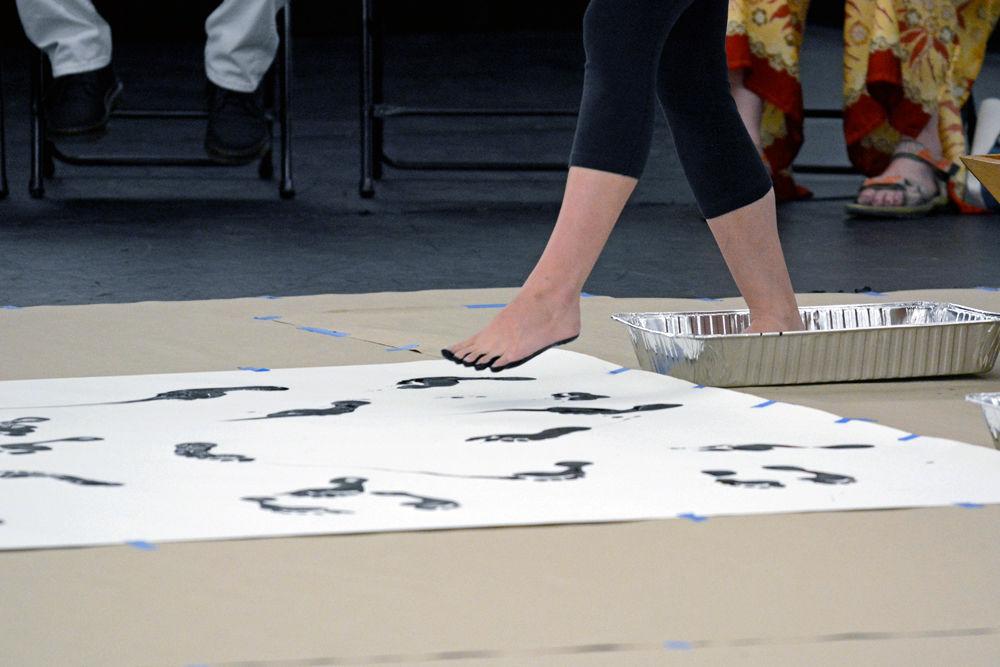 A dancer prepares to leave her footprint on a piece of paper during the Master Class featuring a creation of "John Cage's STEPS: A Composition For A Painting" on Wednesday, Sept. 19 in Carmichael Gymnasium. Master Classes are dance classes offered by the NC State Dance Program which gives students, staff, and faculty members a chance to learn something new.