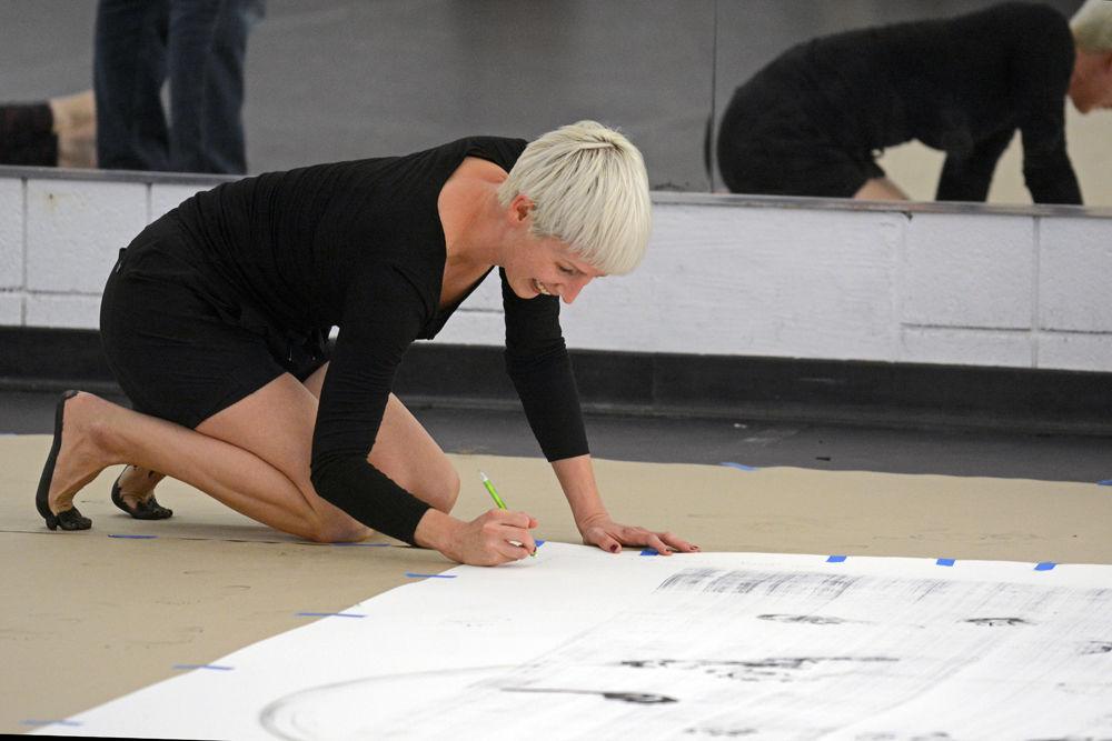 Justin Tornow, a dancer and choreographer based in Durham, NC, signs and titles her recreation of "John Cage's STEPS" during a Master Class hosted by the NC State Dance Program in Carmichael Gymnasium on Wednesday, Sept. 19. According to artist Ray Kass, who was invited to the Master Class, the original artist John Cage stated, "The work may be recreated, but it must remain in the spirit of the original."