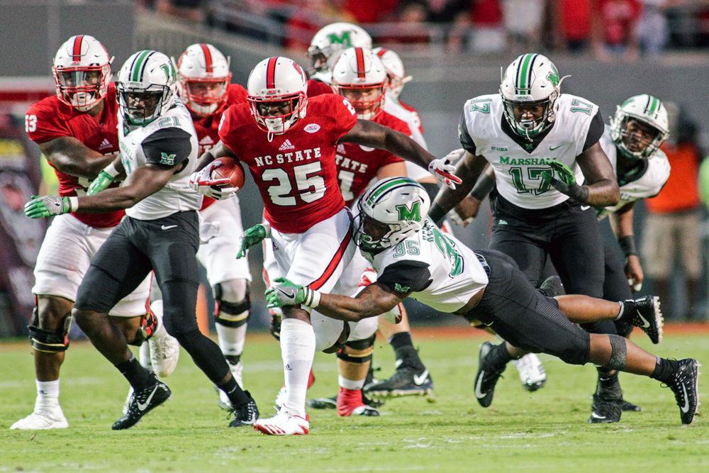 Junior running back Reggie Gallaspy Jr. drags a Marshall defender during his run on&#160;Sept. 9, 2017 in Carter-Finley Stadium. The Wolfpack won 37-20.