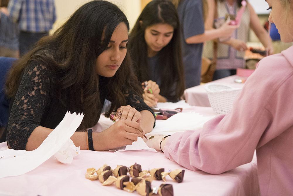 Eiman Azam, a first-year studying business management, applies henna on a guest at Talley Student Union on Friday, Sept. 28, 2018. The Chocolate Festival, hosted by the Women's Center, raises money for the Kay Yow Cancer Fund.&#160;&#160;