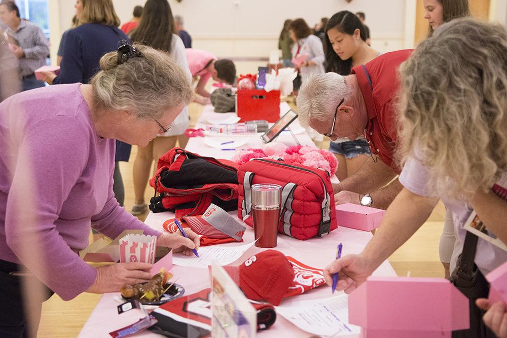 Guests of the Chocolate Festival place bids at the silent auction at Talley Student Union on Friday, Sept. 28, 2018. The Chocolate Festival, hosted by the Women's Center, raises money for the Kay Yow Cancer Fund.&#160;&#160;