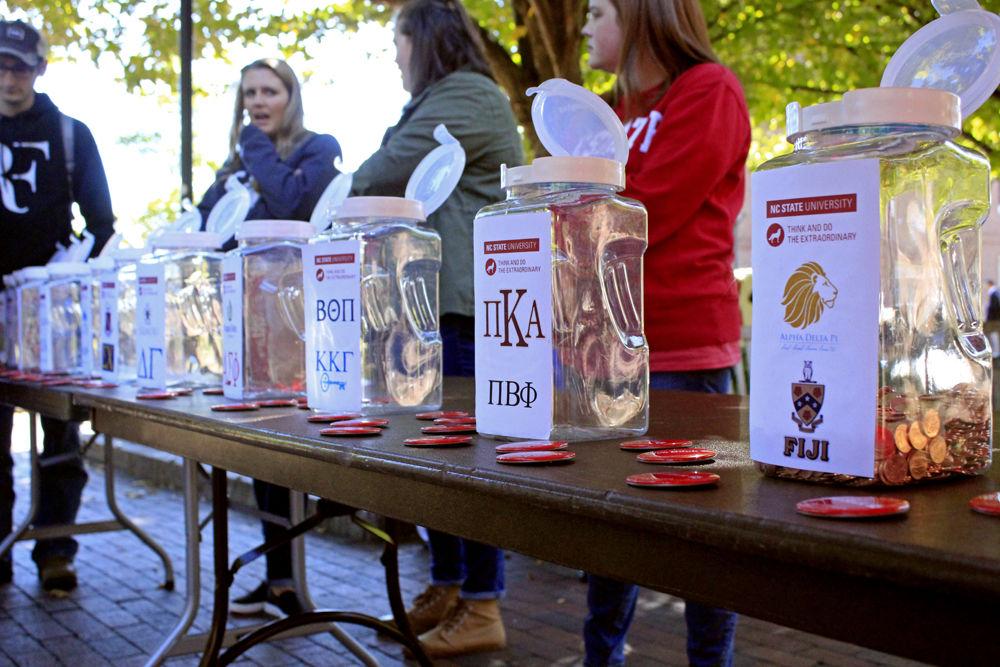 Jars are set up for different organizations to compete in penny wars for Red and White Week in Wolf Plaza on Monday, Oct. 29. The jars will be filled during the week, and all of the profits go towards the Student Emergency Fund.