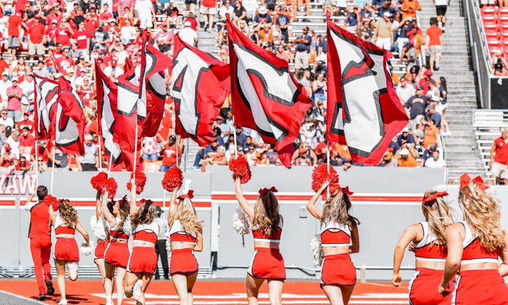 Members of the NC State Cheerleading Team run flags out onto the field after a score on Saturday, Sept. 29 at Carter-Finley Stadium. The Wolfpack beat Virginia 35-21.
