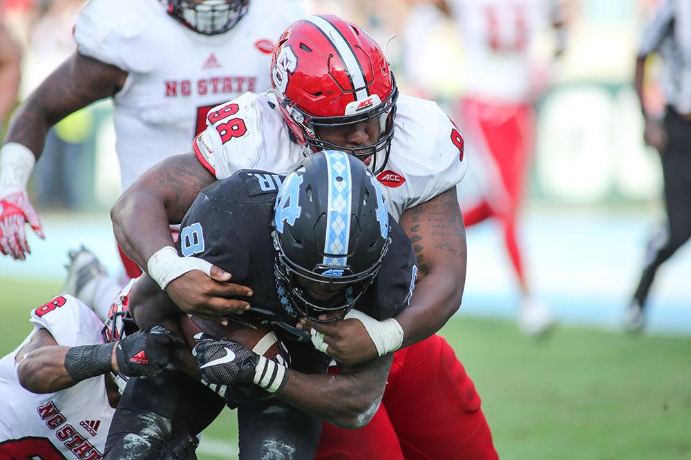 Junior defensive tackle B.J. Hill and graduate nickelback Niles Clark&#160;go in for a tackle during the 28-21 win over UNC-CH in Kenan Stadium on Nov. 25, 2016.