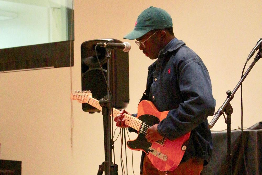 Tim Mensa, a third-year studying communication, performs at Windhover Open Mic Night on Thursday, Oct. 18 in Caldwell Lounge. Students performed original musical and literary pieces at the event.