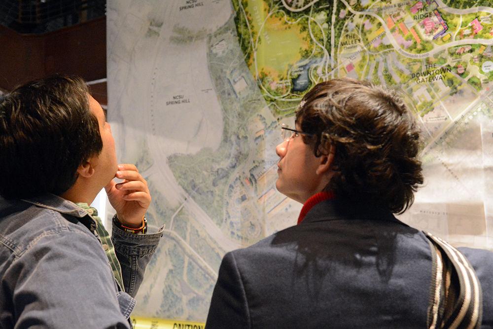 Avery Bartlett-Golden, a fifth-year studying horticultural science, and Matt Snider, a graduate student in the forestry and environmental resources program, look at a map of Dorothea Dix Park at the Dorothea Dix Park University Remix, held at the Transfer Co. Food Hall last Friday, Nov. 16. The event was held to get university student feedback about future plans for the park. "It could create a cool public space and cater to a wide plethora of people," Snider said.