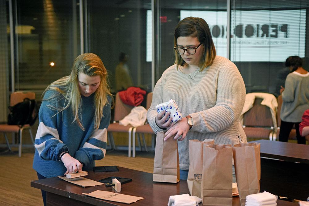 Riley Reinhard, a second-year studying electrical engineering, and Kat Kirby, a fourth-year majoring in women&#8217;s and gender studies, pack paper bags with period products during the PERIOD @ NC State packing party on Tuesday, Nov. 27 in Talley Student Union.