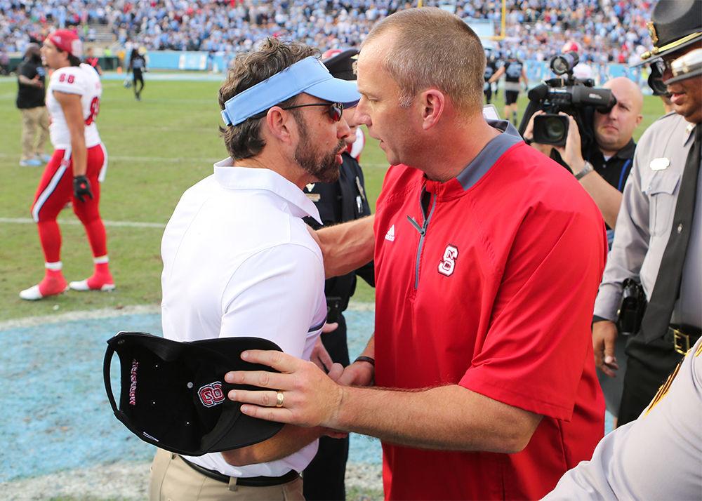 Head coaches Dave Doeren and Larry Fedora shake hands after the 28-21 win over UNC-Chapel Hill in Kenan Stadium on Nov. 25, 2016.