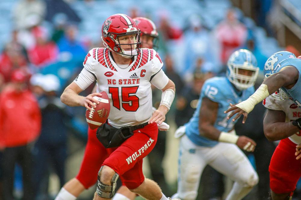 Graduate quarterback Ryan Finely gets flushed from the pocket on Saturday, Nov. 24 in Kenan Memorial Stadium. Finley had 200 yards passing, completing 16 of 28 attempts with one interception. The Wolfpack pulled off a 34-28 overtime win over UNC-Chapel Hill.