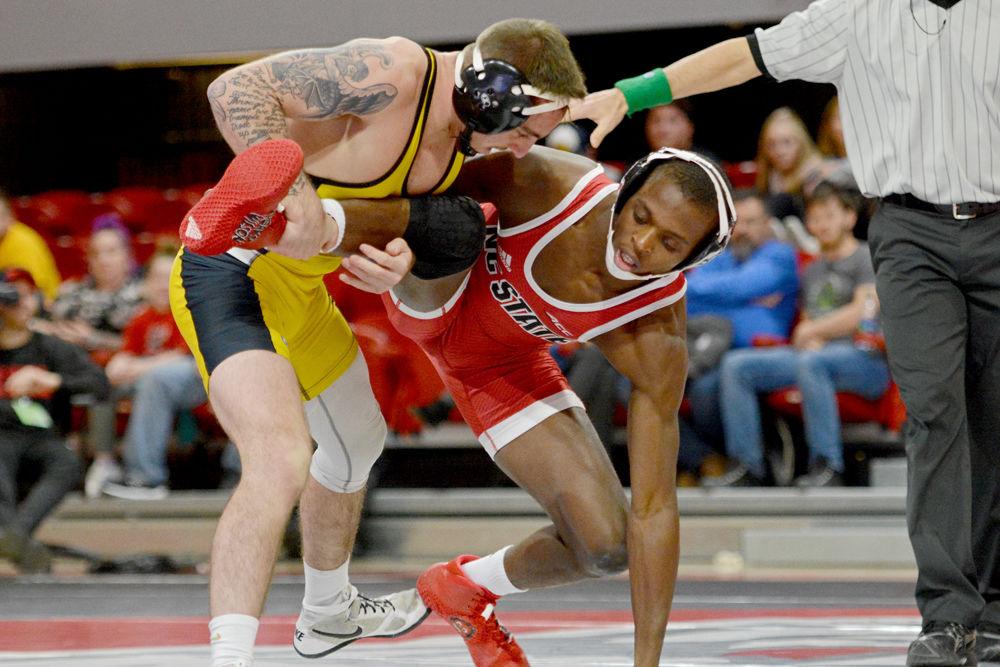 NC State player Tariq Wilson struggles against Appalachian State&#8217;s Codi Russell in Reynolds Coliseum on Tuesday, Dec. 4. Wilson won over Russell 5-2 in their match and the Wolfpack won 29-9 overall.