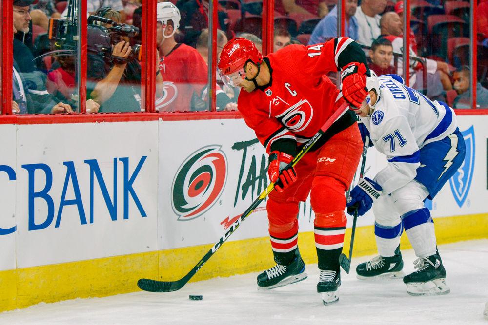 Carolina Hurricanes captain and forward Justin Williams fights to keep control of the puck against Tampa Bay Lightning center Anthony Cirelli on Wednesday, Sept. 19 in PNC Arena. The Hurricanes beat the Lightning 6-1.