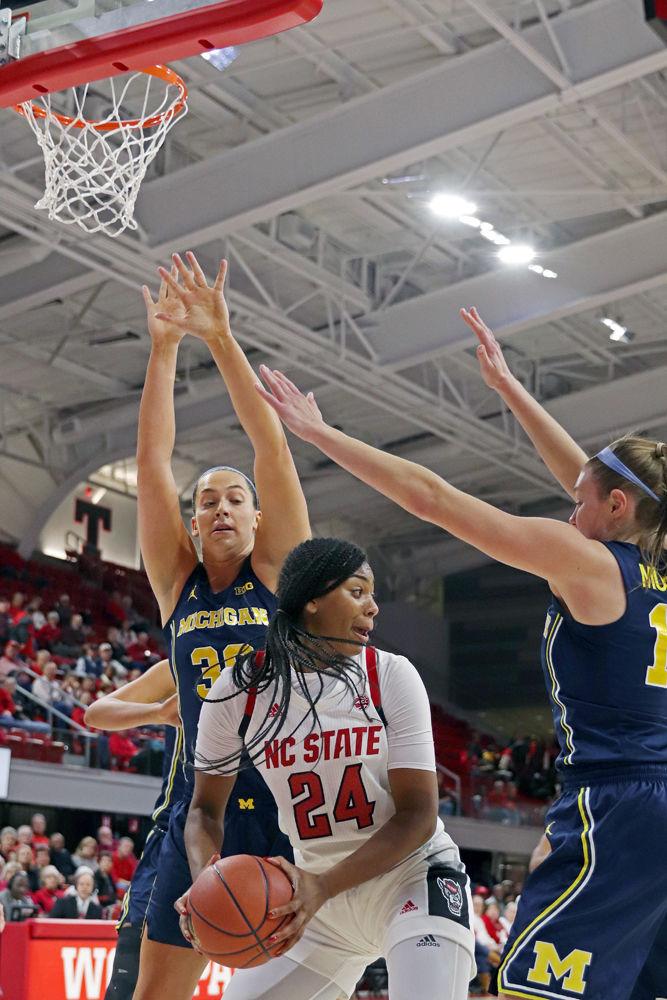 Junior forward Erika Cassell looks for a pass while being pressured by Michigan center Hallie Thome and guard Nicole Munger in Reynolds Coliseum on Thursday, Nov. 29. The lead changed 12 different times throughout the game and the Wolfpack ended up winning 66-55.