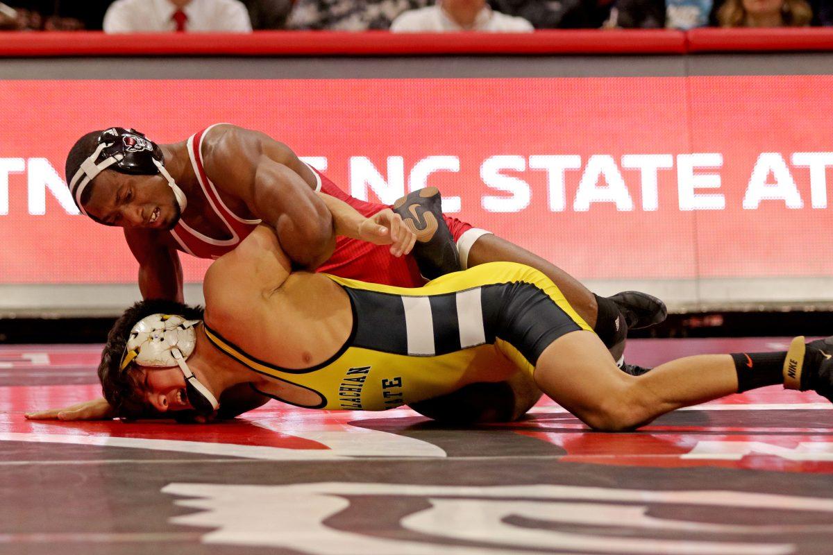 Redshirt senior Jamal Morris holds down Appalachian State's Irvin Enriquez at Reynolds Coliseum on Dec. 4, 2018. Morris won the bout with a 10-4 victory, increasing the lead over the Mountaineers 10-0.
