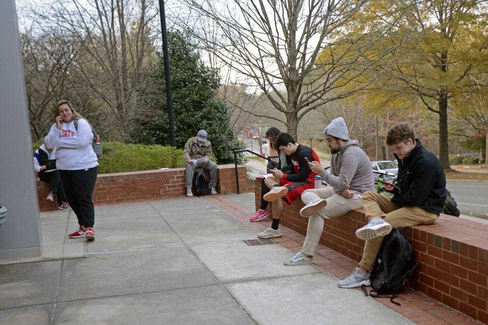 Distance education students wait outside of Venture IV to take their exams at Centennial Campus Testing Center on Thursday, Dec. 13. In order to cut down on the lengthy lines that formed around Venture IV earlier in the week, DELTA Testing Services encouraged students to sign in online before coming to the center. When asked how long he had been waiting to take his exam after signing in, second-year business administration student Eric Todd (right-most) said, "I've been waiting about three hours".