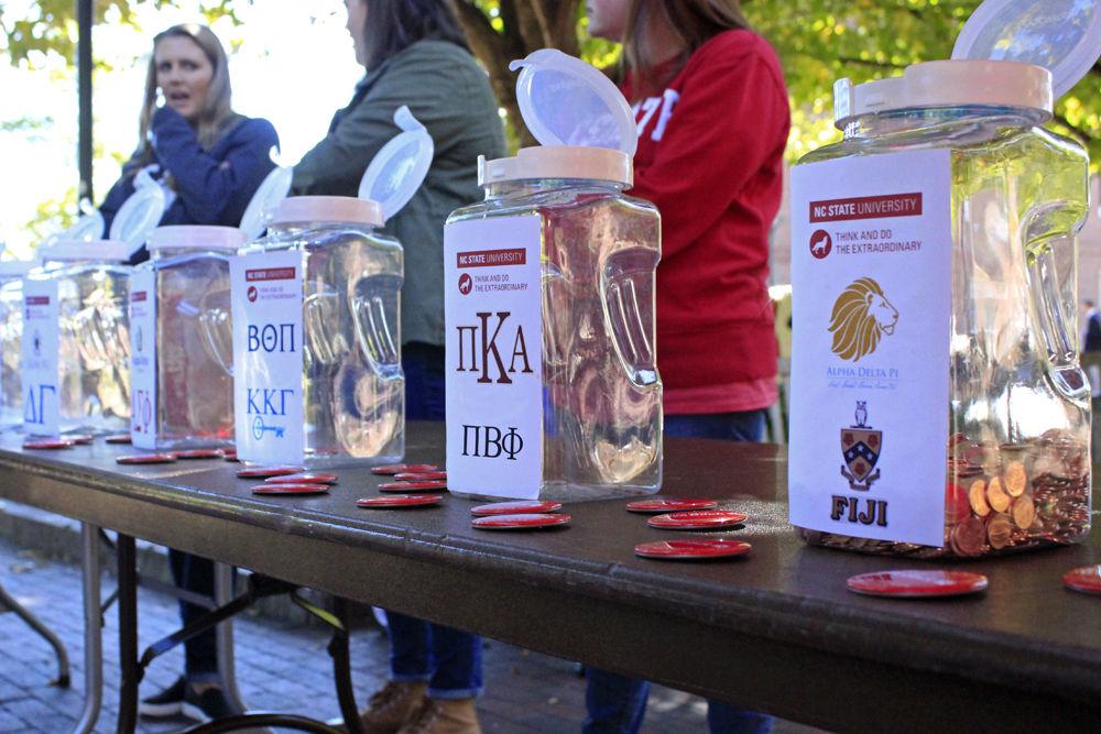 Jars set up by Beta Theta Pi and Pi Kappa Alpha fraternities, along with other organizations, stand on display at Wolf Plaza on Monday, Oct. 29, 2018. The jars collected money for Penny Wars as part of Red and White Week, and all of the profits went towards the Student Emergency Fund.