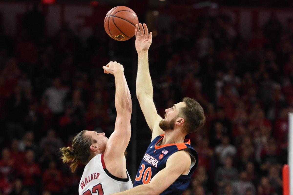 Graduate forward Wyatt Walker wins the tip-off against Virginia center Jay Huff at PNC Arena on Tuesday, Jan. 29. The Wolfpack suffered a close overtime loss to UVA 66-65. Walker recorded 11 points, 3 blocks and got 7 rebounds against the Cavaliers*.&#160;*Editor's note: the caption has been updated to correct Virginia's nickname.