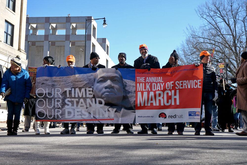 The front line of the 39th Annual MLK Memorial March holds an event banner on W. Edenton St. in downtown Raleigh, minutes before the beginning of the march on Monday, Jan. 21.