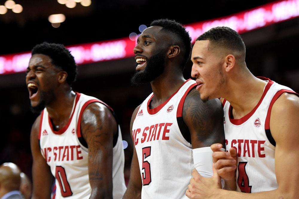Redshirt sophomore forward DJ Funderburk, graduate guard Eric Lockett and freshman forward Jericole Hellems celebrate an NC State basket at PNC Arena on Tuesday, Jan. 29. The Wolfpack suffered a 66-65 loss in overtime.