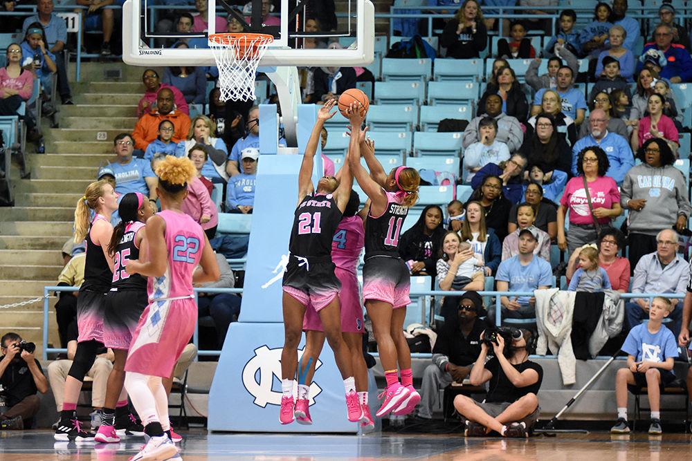 Senior forward DD Rogers and graduate guard Kiara Leslie reach up for a rebound during the game against UNC-Chapel Hill on Sunday, Feb. 24, 2019 in Carmichael Arena. The Wolfpack beat the Tarheels 74-69.