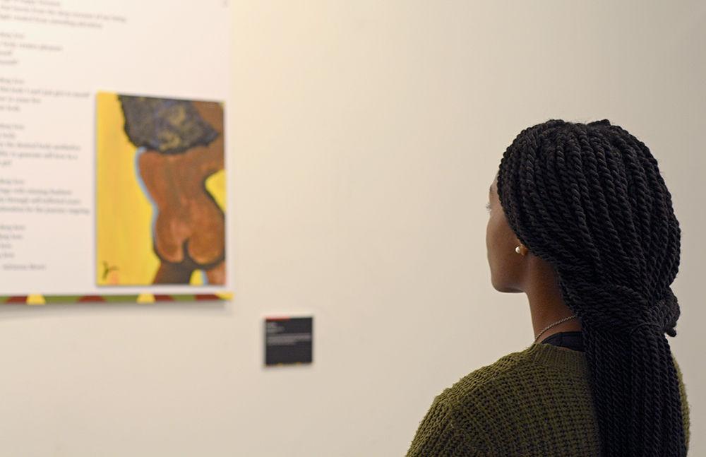 Toinette Powers, a third-year majoring in international studies, looks at one of the pieces on display at the &#8220;Politicization and Sexualization of Black Bodies&#8221; art exhibit. The opening reception was held on Monday, Feb. 11 at the African American Cultural Center Witherspoon Art Gallery, and was hosted by the NC State Women's Center and the African American Cultural Center. The gallery features stories and paintings created by NC State students and staff.