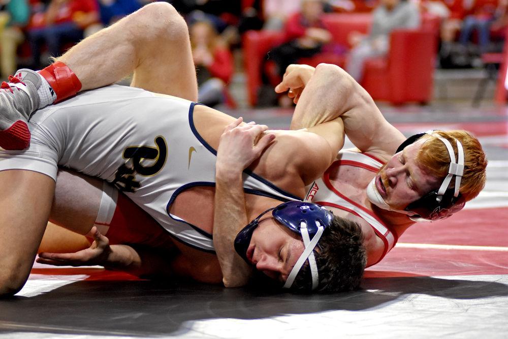 Graduate Justin Oliver, No. 8 in the 149-pound weight class, grapples with Pittsburgh senior Robert Lee at Reynolds Coliseum on Sunday, Feb. 10, 2019. The Wolfpack lost to the Panthers 18-16, its first home loss of the season.