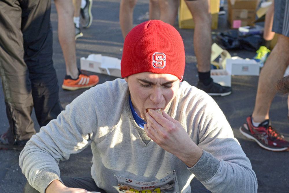 Trey Corriher, a 20-year old from Mooresville, North Carolina, struggles to fit another doughnut into his mouth at the midway point during the Krispy Kreme Challenge on Saturday, Feb. 2, 2019. In this annual event, participants must run 5 miles from the Memorial Bell Tower and back, stopping at the 2.5 mile mark to eat a dozen doughnuts.