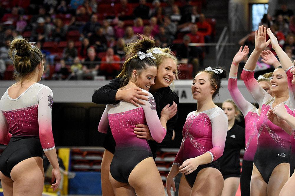 Senior Paris Phillips is congratulated by teammate Kasey Nelson after she scored a 9.875 on her floor routine on Saturday, Feb. 9. The NC State gymnastics team beat Pittsburgh 196.400-194.825&#160;at Reynolds Coliseum.