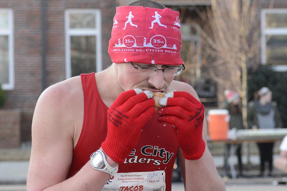 Jacob Wormald from New Hampshire finishes a doughnut at the midway point during the 15th annual Krispy Kreme Challenge on Saturday, Feb. 2. Wormald placed first in his gender and first overall, finishing the race in under half an hour.