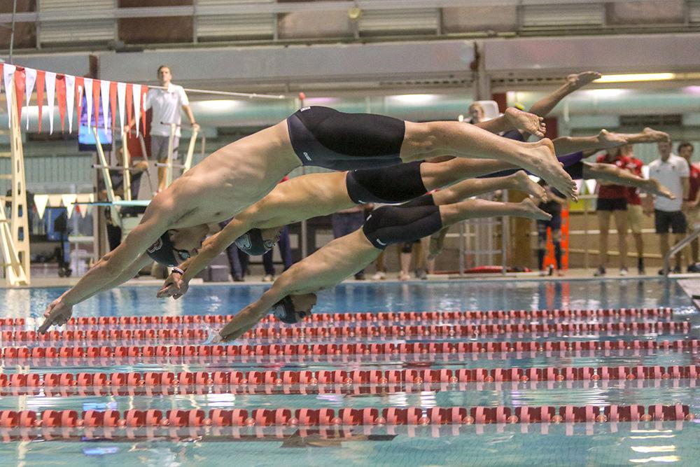 Members of the men's swimming team jump off the starting blocks for the hypoxic challenge, a 50-yard underwater kick. This was one of many events held at the fourth annual Wolfpack Games held on Friday, Sept. 28 In the Casey Aquatic Center.