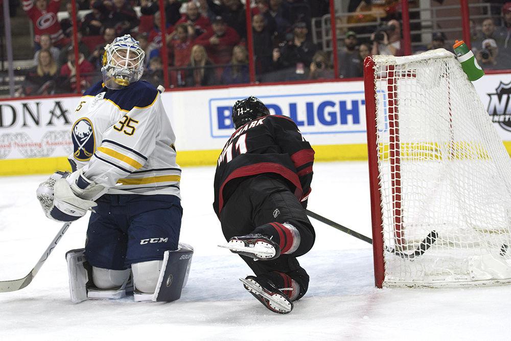 Center forward Lucas Wallmark sneaks in a point behind Buffalo Sabres goalie Linus Ullmark during the first period in PNC Arena, Saturday, March 16.&#160;