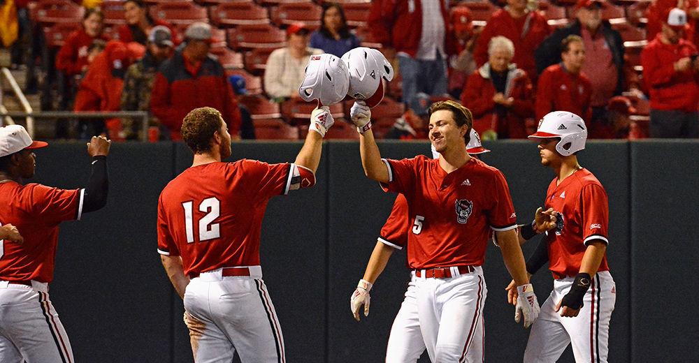 Sophomore catcher Patrick Bailey and junior catcher Brad Debo high five during the game against Florida Sate on Friday, March 15 at Doak Field. The Wolfpack won 16-0.