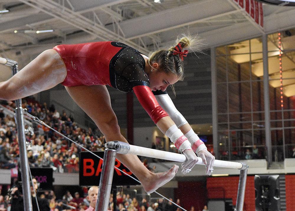 Melissa Brooker, a junior from Charlotte, North Carolina, performs on the bars during the meet against Ohio State on Saturday, Jan. 12, 2018 in Reynolds Coliseum. The Wolfpack, despite losing to the Buckeyes 196.025-194.925, set a new team high score.