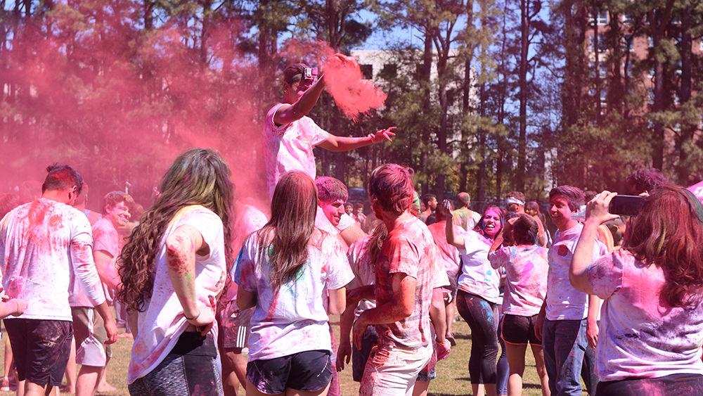Palak Desai, a fourth-year studying mechanical engineering, dumps out a bag full of gulal power during the Holi celebration on Sunday, March 24, in Lee Field. Holi celebrates the coming of spring, love, and forgiveness.