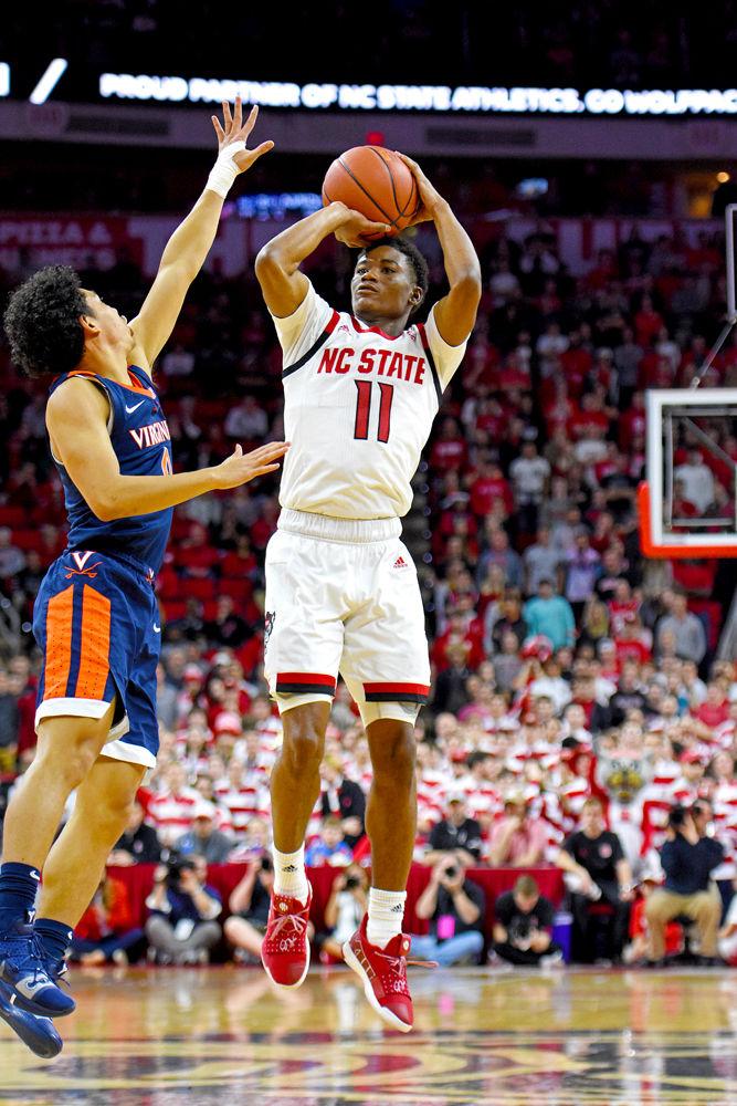 Junior guard Markell Johnson attempts a 3-point shot against Virginia guard Kihei Clark at PNC Arena on Tuesday, Jan. 29. Johnson recorded 14 points and six rebounds in the Wolfpack's 66-65 overtime loss.